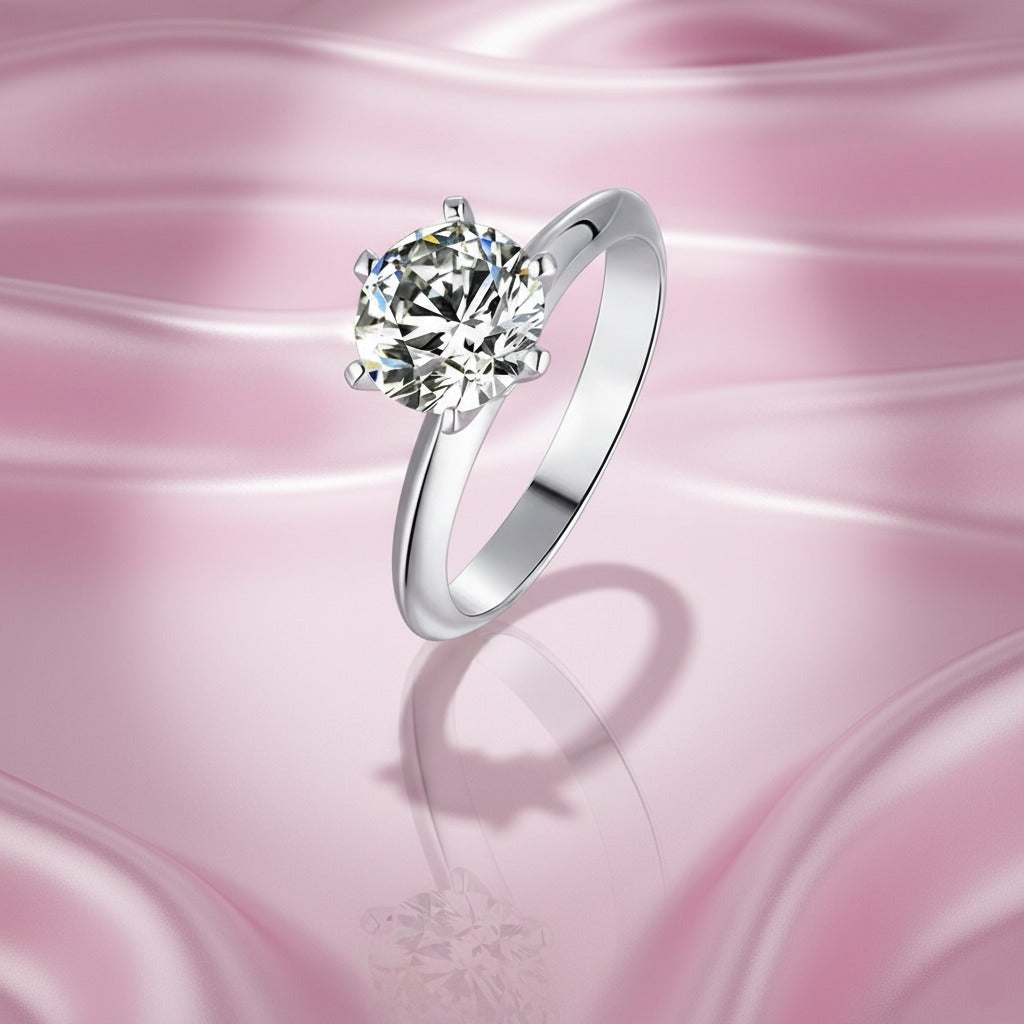 Silver ring with a large diamond on a pink background