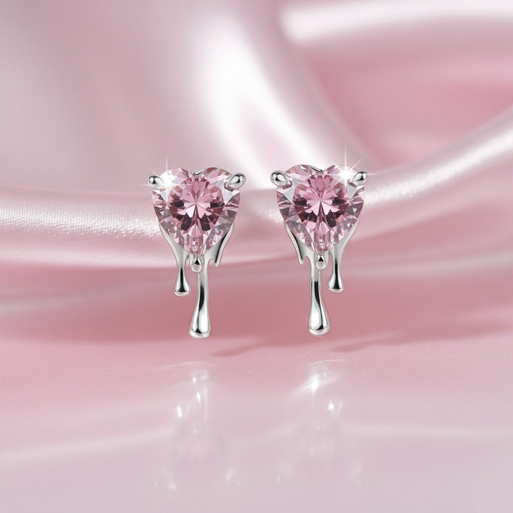 Heart-shaped pink gemstone earrings on a pink satin background