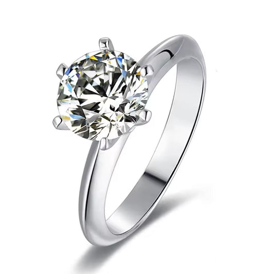 Silver ring with a large diamond and a smaller diamond next to it on a white background, featuring the brand 'BTB'.