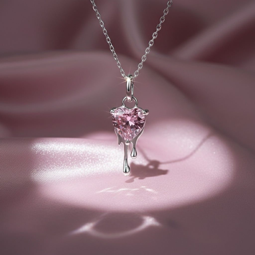 Pink heart-shaped pendant on a silver chain against a pink background